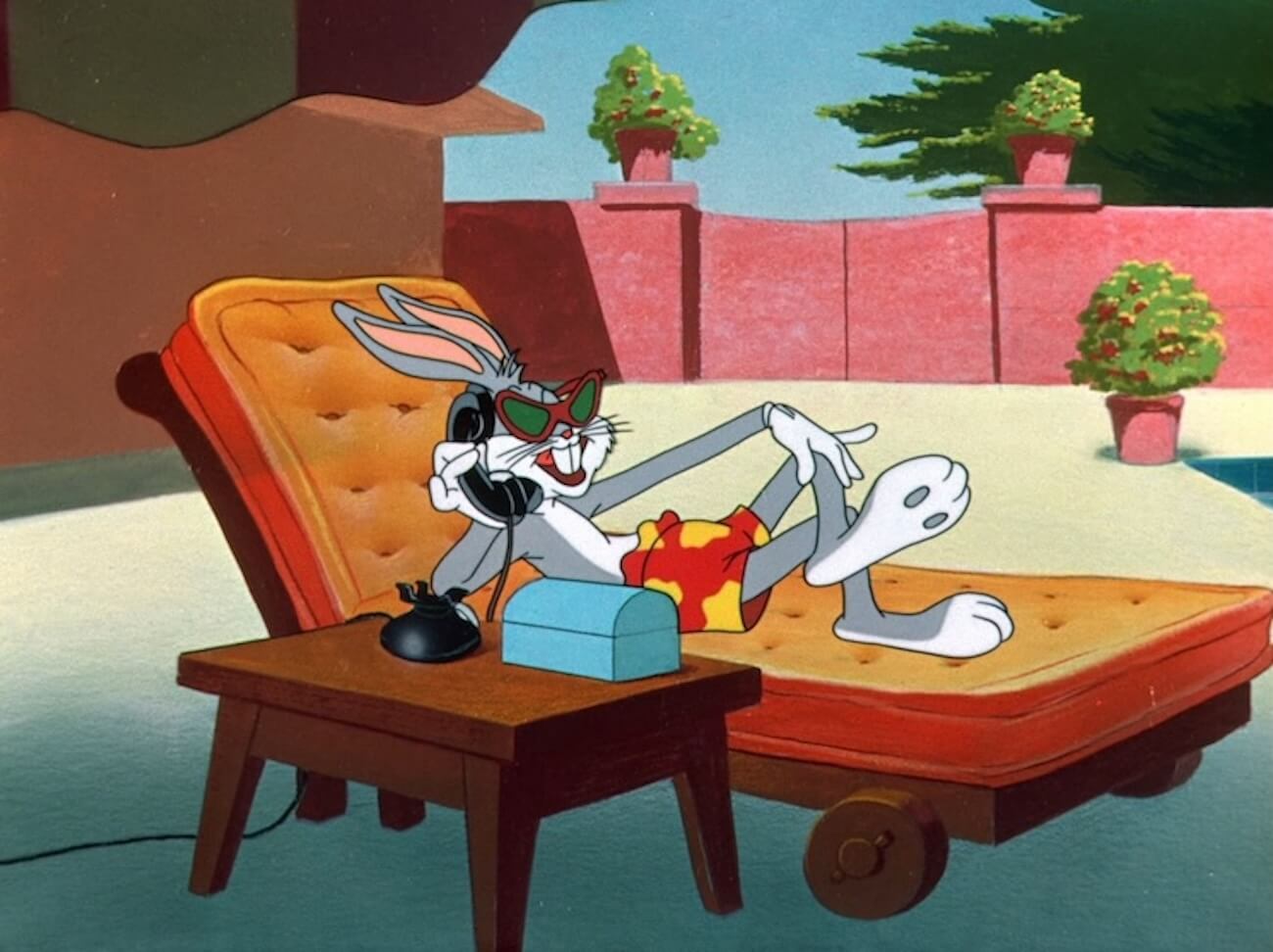 A screenshot of bugs bunny laying on a lounge chair while on the phone.