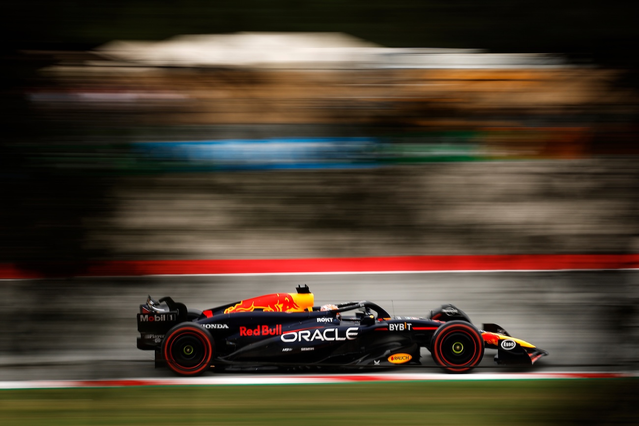 An Oracle Red Bull Racing Formula 1® car drives along a race track in profile view.